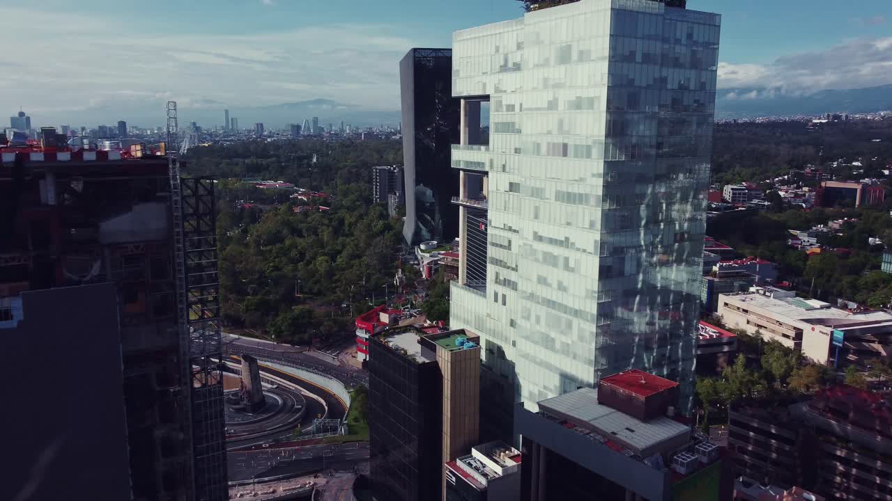 entre grandes edificios de una panorámica de las avenidas periferico y paseos de la reforma, el bosque de chapultepec, el auditorio nacional y la bandera mexicana están en la toma