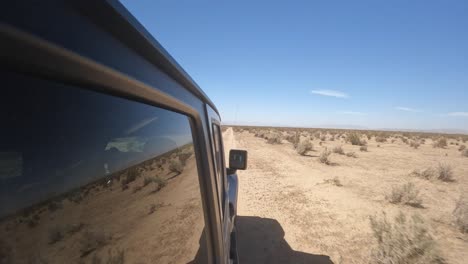 navigating rugged terrain in the backroads of the mojave desert in a four-wheel drive vehicle - passenger side view