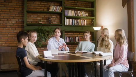 Teacher-and-students-reading-books-in-round-table