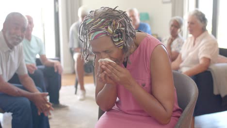 distressed diverse seniors crying and talking in group therapy session, unaltered, slow motion