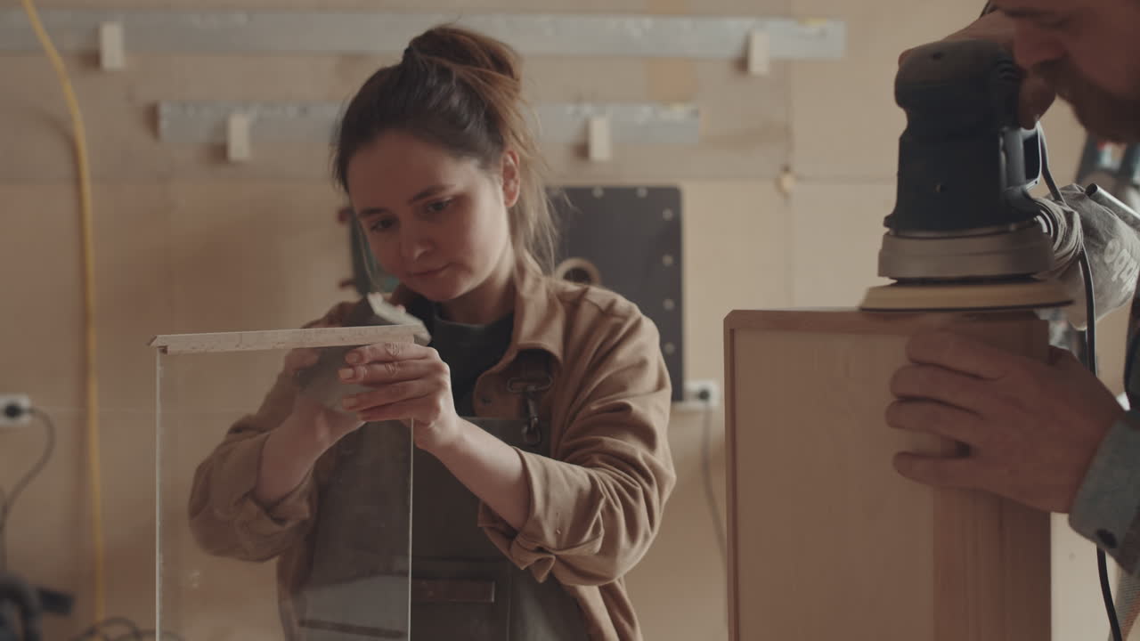 Man and Woman Sanding Parts of Wooden Drawer