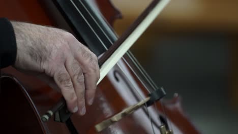 Musician-hand-playing-cello-on-a-classical-music-concert,-closeup-of-instrumentist