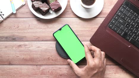 charging smartphone using wireless charging pad on table