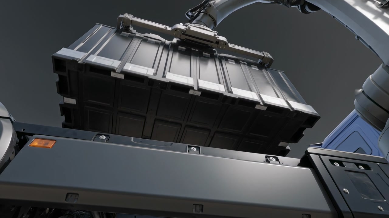 Lowering robotic arm gripping battery module over vehicle chassis, aligning ridges into rails