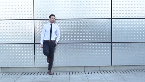 Smiling-bearded-businessman-in-suit-against-wall