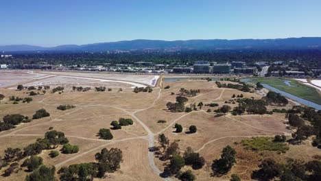 aerial of bedwell bayfront park in menlo park with mounatins and corporate buildings in front, silicon valley california