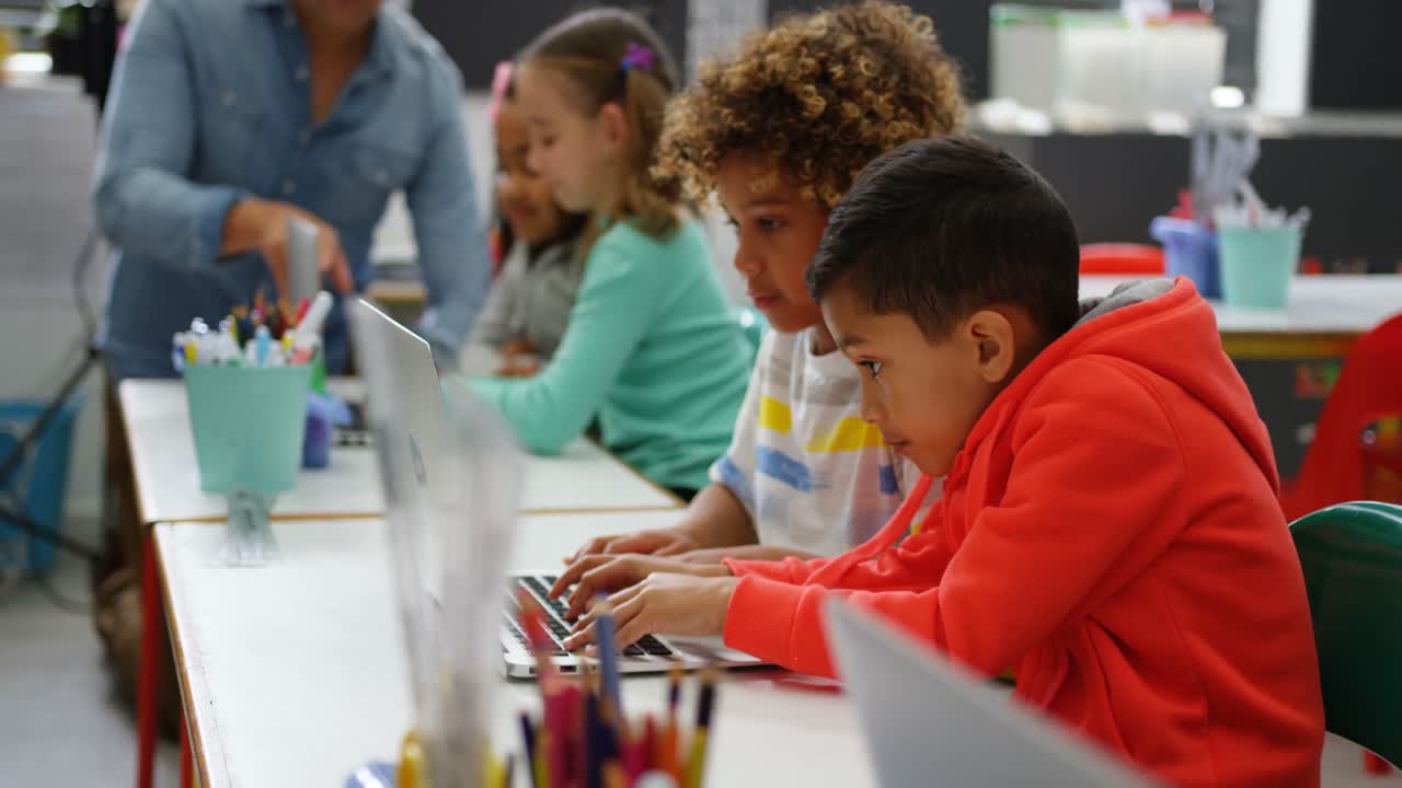 Side view of Mixed-race schoolboys studying on laptop in the classroom 4k