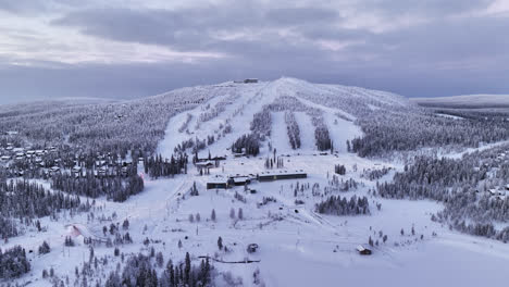 tomada panorámica de un avión no tripulado dando vueltas por las laderas de iso-syote, amanecer de invierno en finlandia