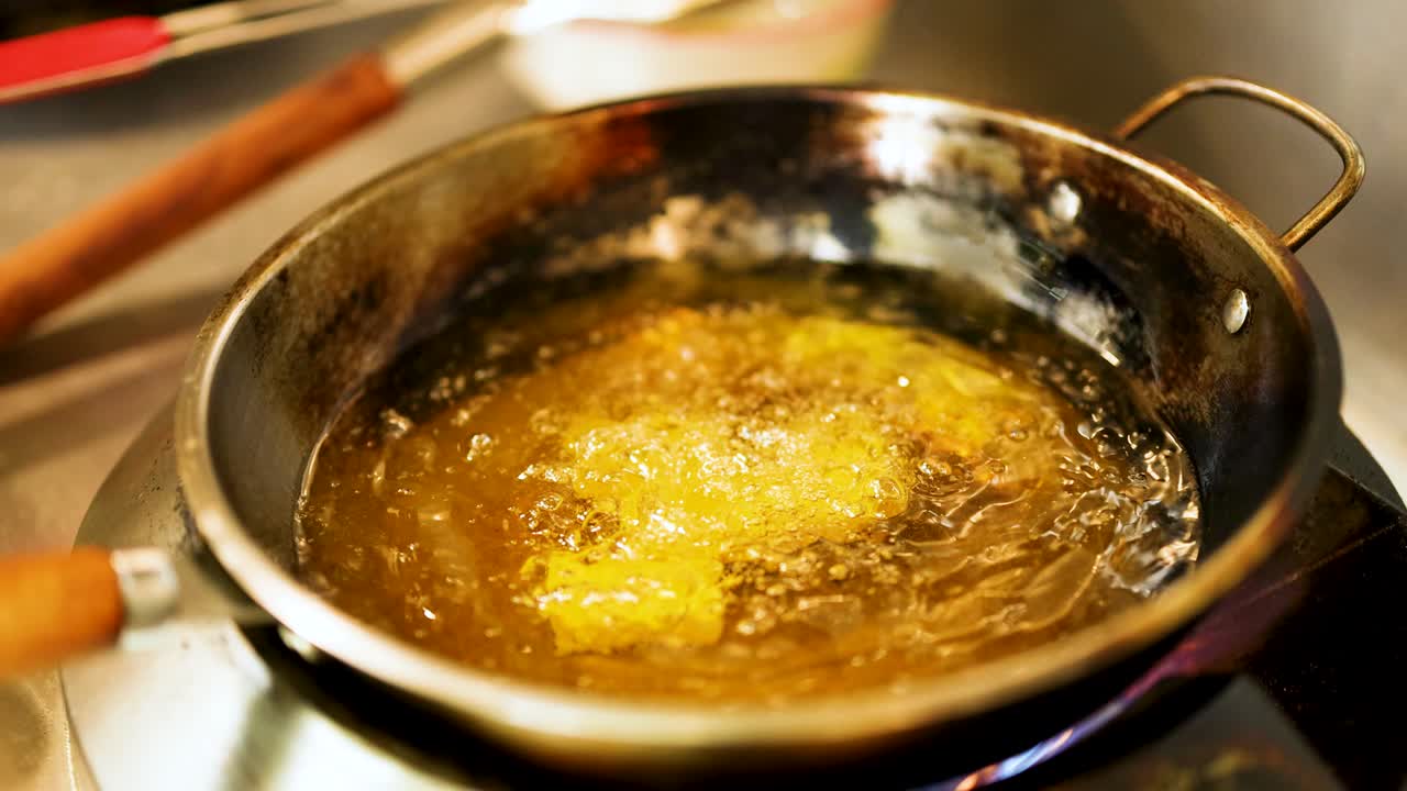 Food frying in a pan with bubbling oil