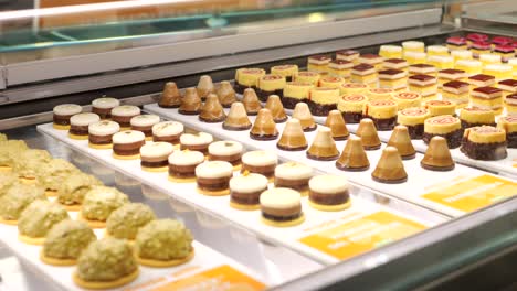 Rows-of-gourmet-sweet-cream-cakes-presented-in-delicatessen-patisserie-SLIDE-SHOT