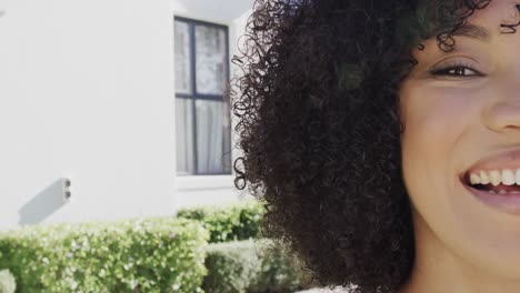 retrato de una feliz mujer afroamericana sonriendo en el jardín, espacio de copia, cámara lenta