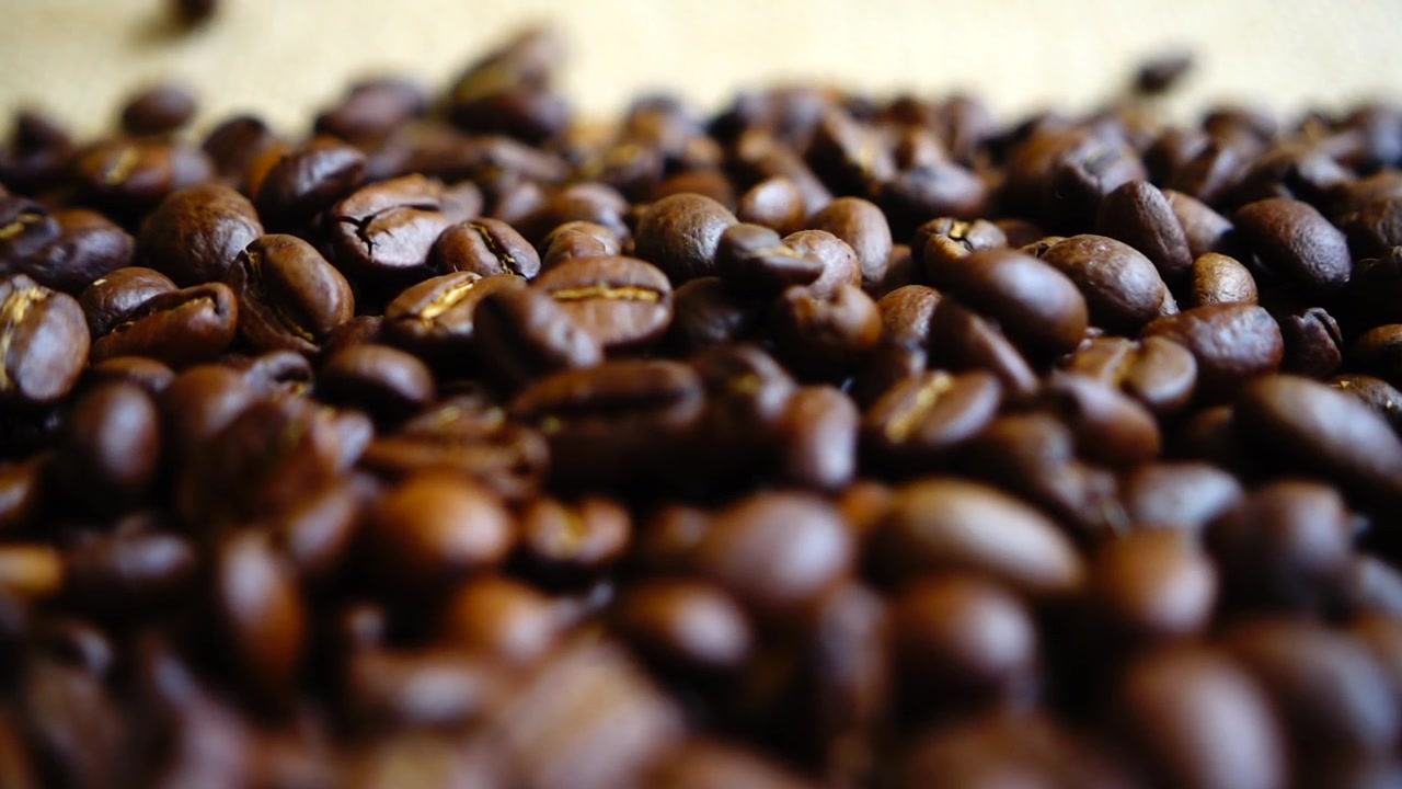 Chicchi di caffè che cadono sul sacco. Al rallentatore.