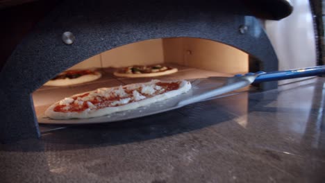 El-Chef-Pone-La-Pizza-De-La-Mesa-De-La-Cocina-En-El-Horno