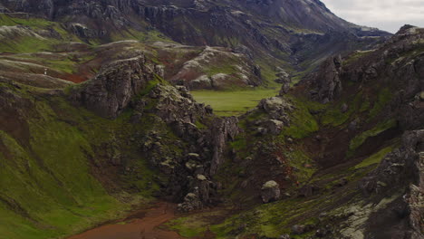 drone shot revealing a small valley on a moss covered hiking trail in the volcanic mountains of iceland