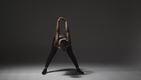 studio shot of young woman wearing gym fitness clothing warming up for exercise 4