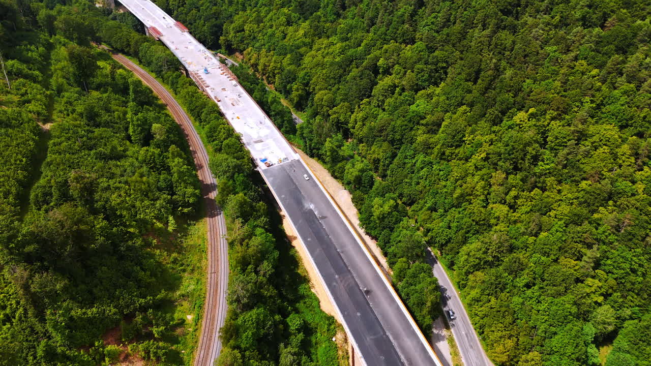 Wide freeway being built over the highways. Top view on the road construction in the mountainous area