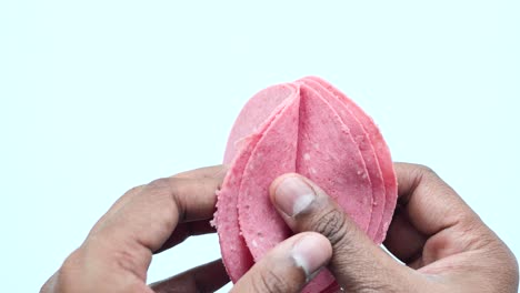 sliced pink meat in hands