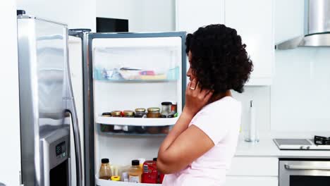 Woman-talking-on-mobile-phone-while-working-in-kitchen-4k