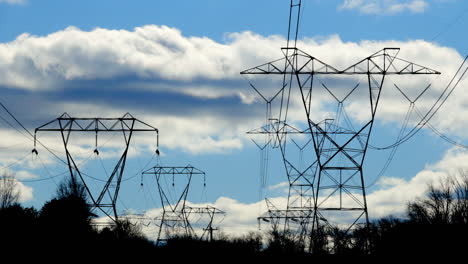 torres eléctricas y líneas de transmisión oscilantes con nubes moviéndose en movimiento de lapso de tiempo