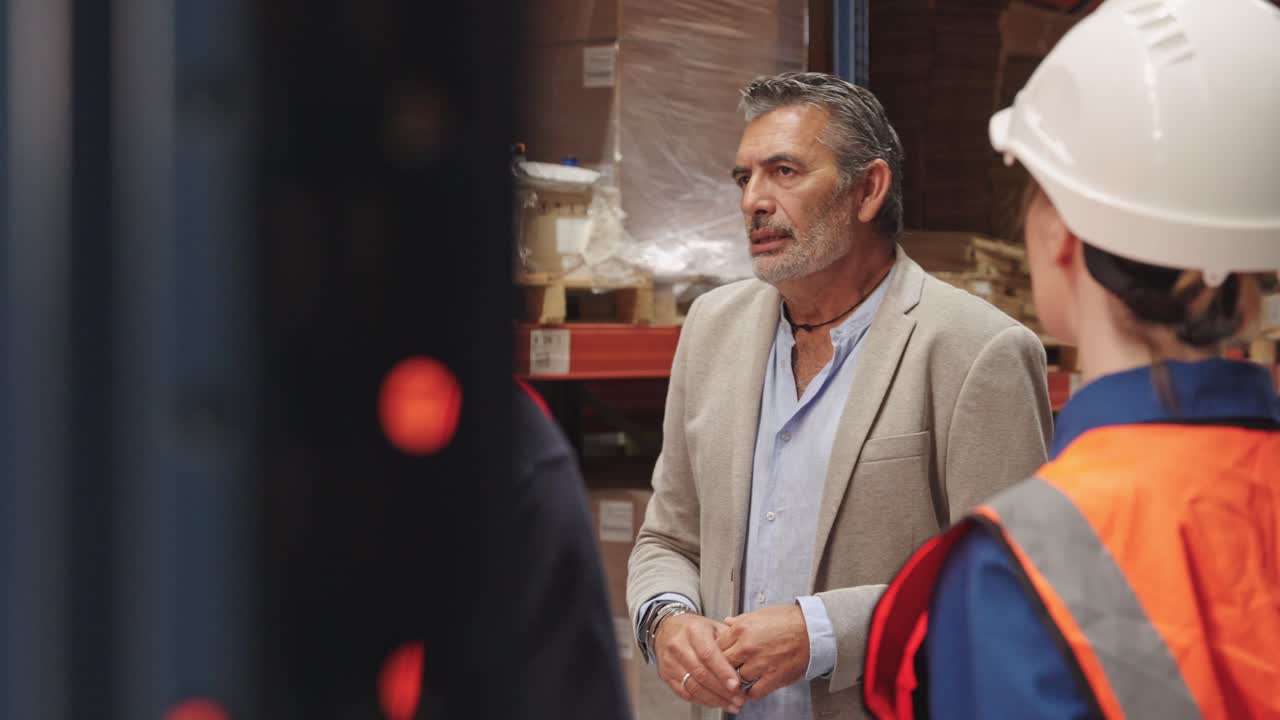 Warehouse workers discussing work in storage facility