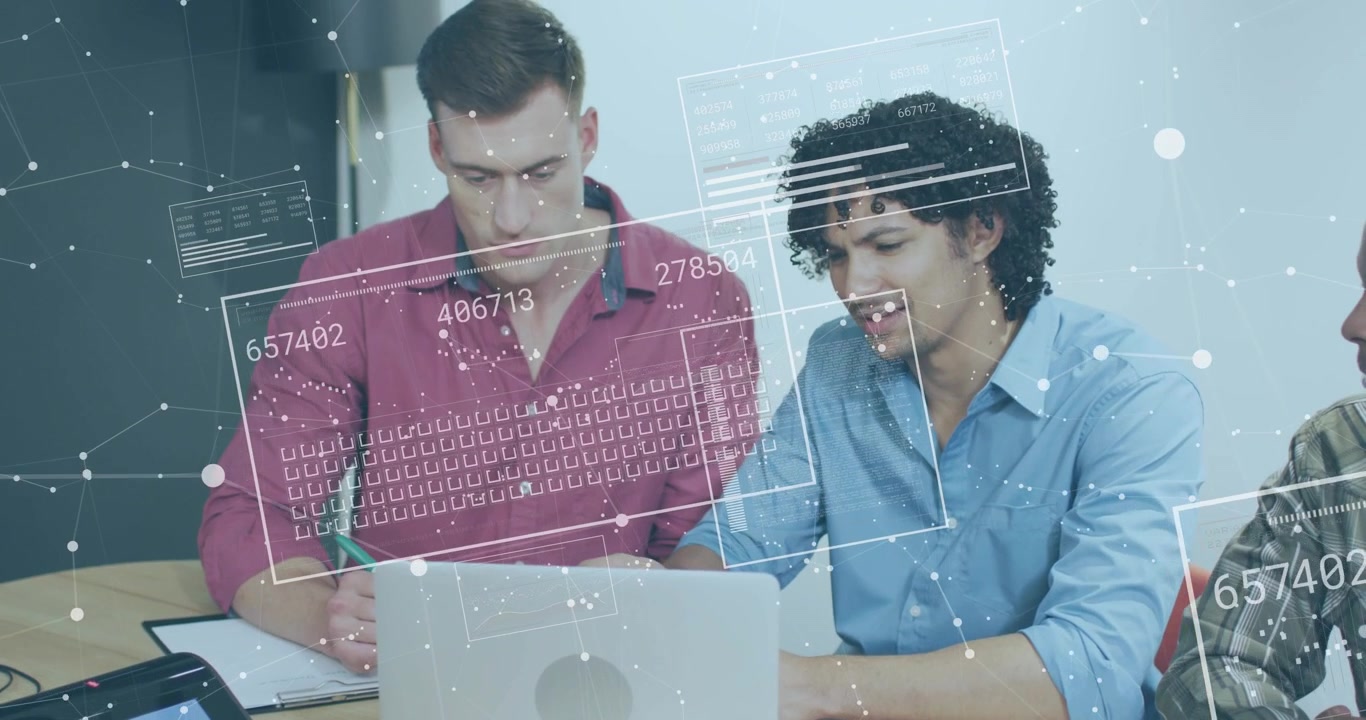 Two colleagues flipping notebook jotting analytics notes while animated grids floating over laptop