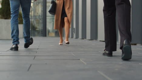 Close-Up-View-Of-The-Feet-Of-Male-And-Female-Pedestrians-Walking-On-Pavement-In-The-Street