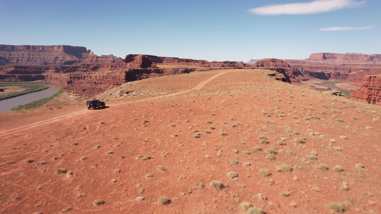 Drone che segue un'auto 4x4 che guida su una strada sterrata verso il bordo di un dirupo a Moab, USA, in 4k