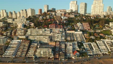 Aerial-view-reversing-from-scenic-Reñaca-beach-resort-hotel-buildings-on-Vina-Del-Mar-waterfront,-Chile