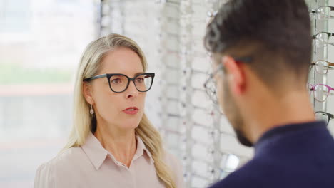 Woman-checking-sight-of-man-buying-glasses
