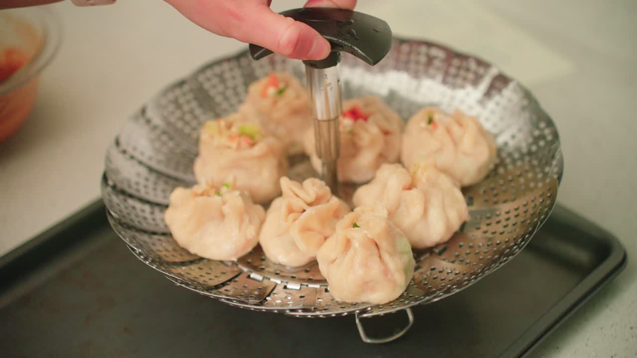 Taking freshly steamed dumplings off of the steamer