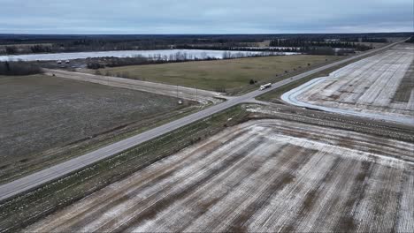 aerial view of rural landscape with farmland and country road in winter