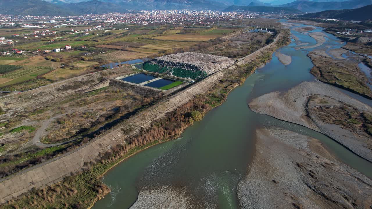 vertedero de basura de la ciudad montaña de residuos sin clasificar en el vertedero junto al río, problema ecológico en elbasan albania