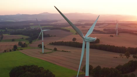 windmills operate at sunset producing renewable energy