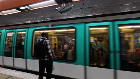 people waiting as subway train arrives and leaves