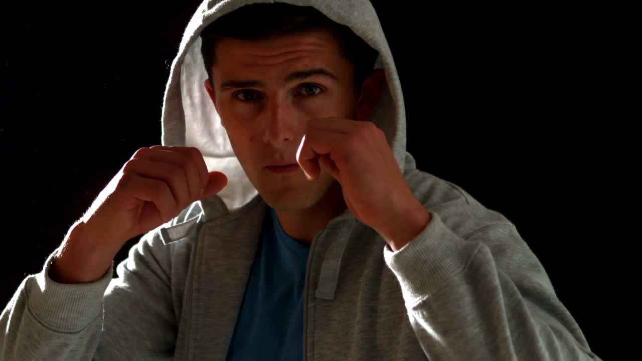 здоровый человек показывает кулаки на черном фоне