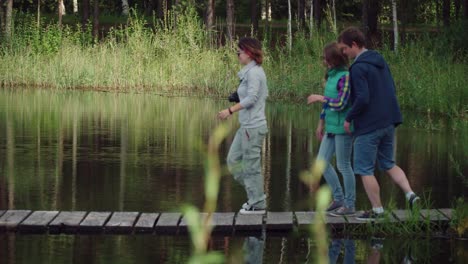 young people rest on wooden bridge by river. youth enjoying weekend