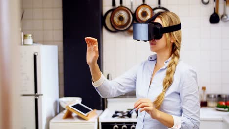 Woman-using-virtual-reality-headset-in-kitchen