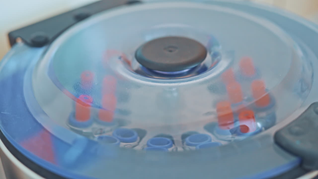 Modern centrifuge machine is working in the medical laboratory. Test tubes with blood inside the centrifuge. Close-up. Top view.