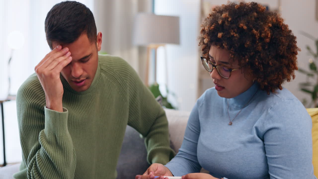 Pregnancy test, stress and couple on a couch