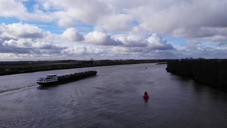 Barcaza-Navegar-En-El-Río-Oude-Maas-Con-La-Marca-Del-Mar-Rojo-Durante-El-Día-Cerca-De-Puttershoek,-Países-Bajos