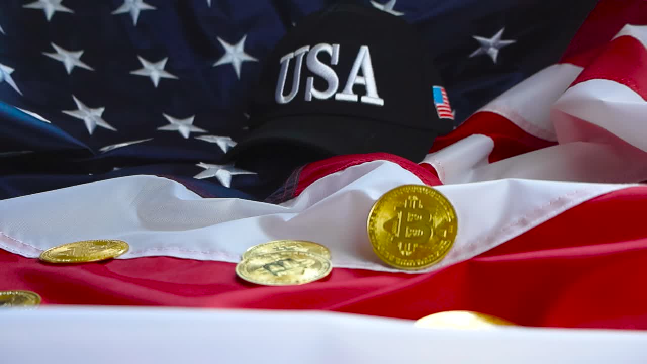 Slowly moving footage of golden shiny and refelective cryptocurrency Bitcoin coins on a United States of America flag with a USA hat in the background under good studio lights. Stars and stripes.