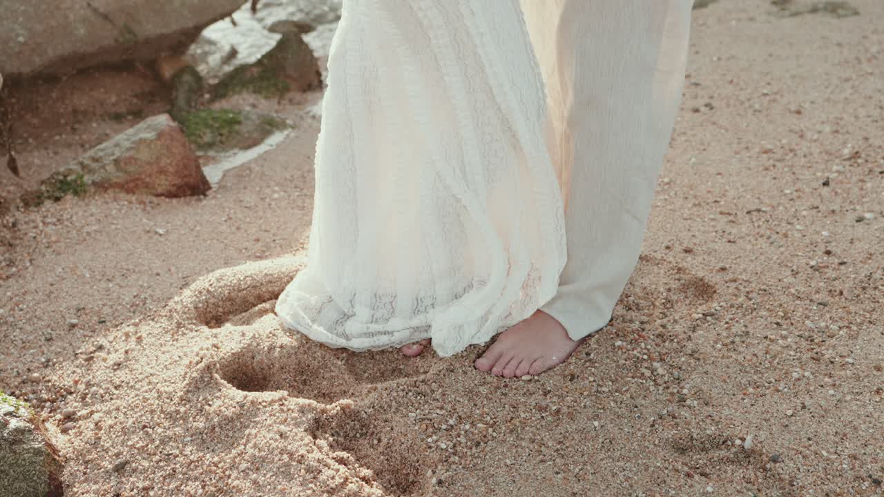 Romantic barefoot couple touching feet on beach sand
