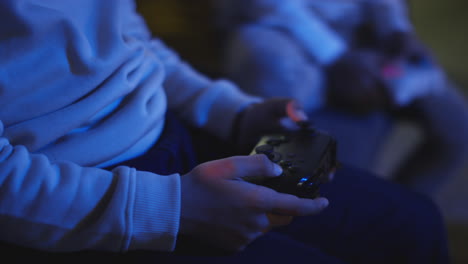 Close-Up-Of-Two-Young-Boys-At-Home-Playing-With-Computer-Games-Console-On-TV-Holding-Controllers-Late-At-Night-9