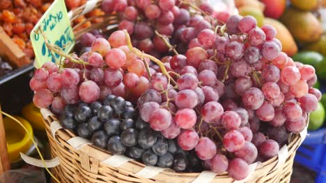 red and black grapes in a basket at a market