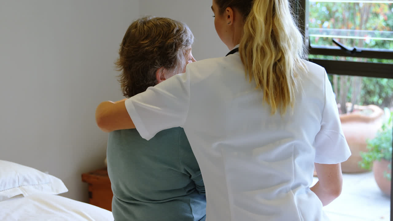 доктор обнимает пожилую женщину на кровати 4к