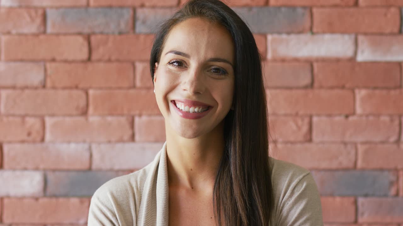 morena elegante alegre cerca de la pared de ladrillo