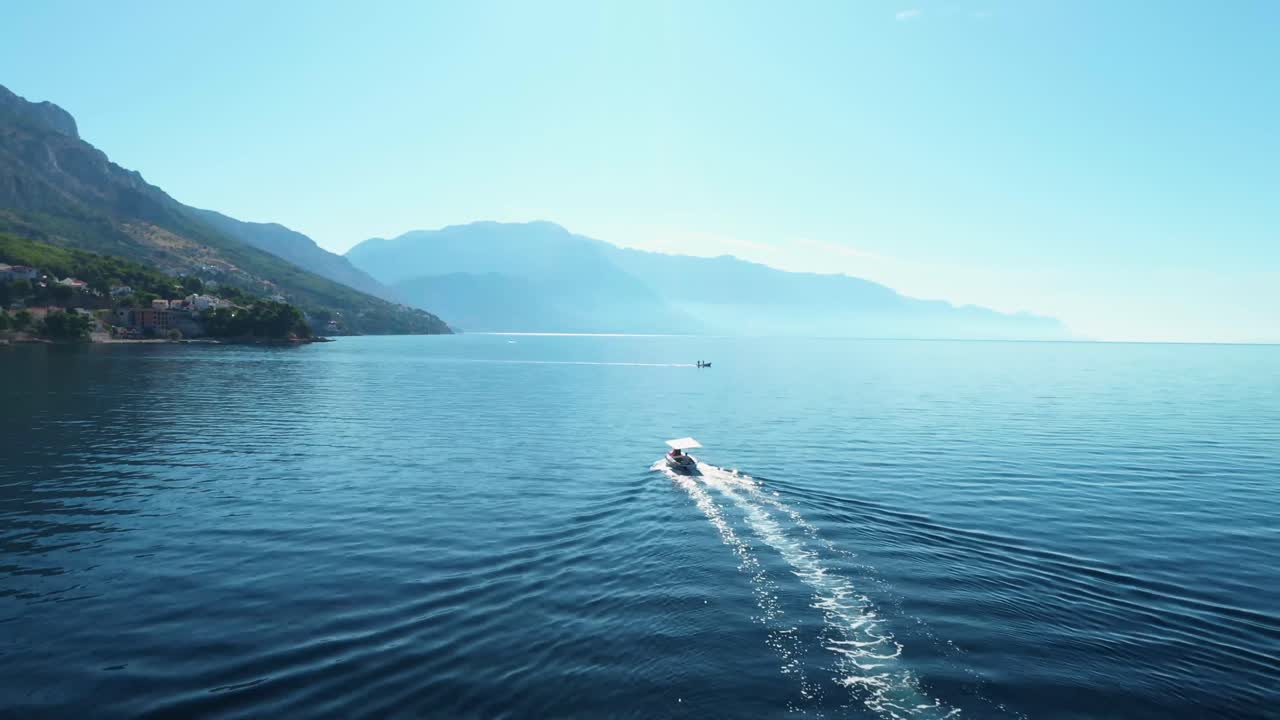 imágenes aéreas de drones siguiendo dos barcos en un mar cerca de la costa en mimice, croacia