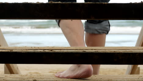 Man-walks-down-wooden-beach-stairs