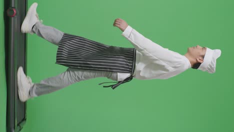 으로 보이는 몸으로 가득 찬 아시아 남성 요리사가 녹색 스크린 배경 스튜디오에서 트레드밀을 고 있습니다.