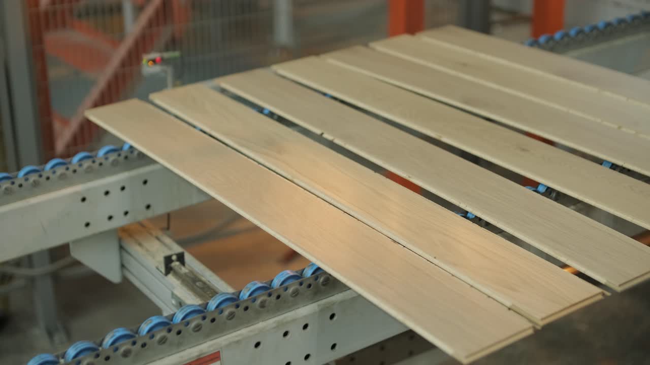 Assi di legno che si muovono su un nastro trasportatore automatizzato in fabbrica.
